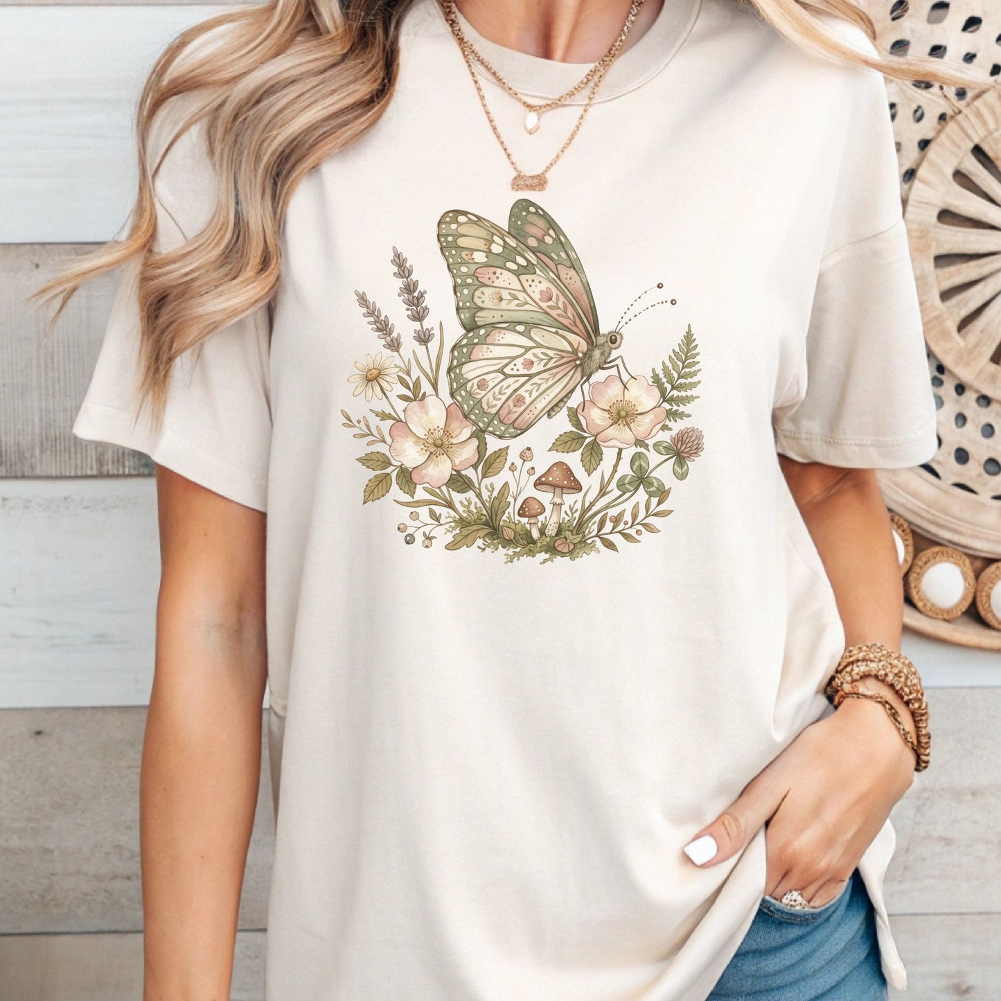 Person wearing a white t-shirt with a butterfly and floral design.