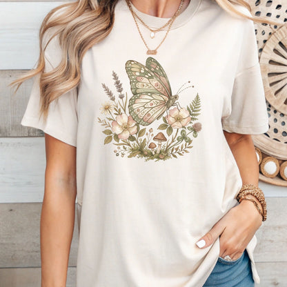 Person wearing a white t-shirt with a butterfly and floral design.