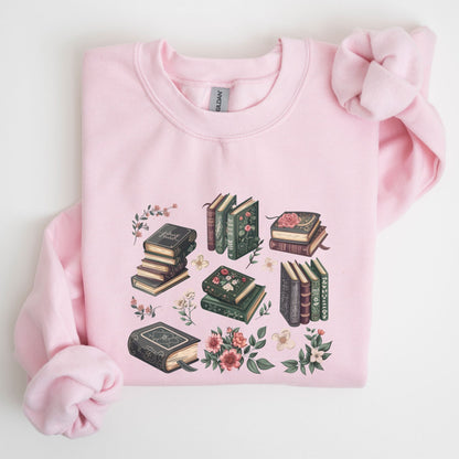 Pink sweatshirt with book and floral design on a light background
