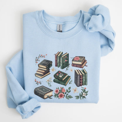 Light blue sweatshirt with book and floral design on a white background