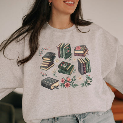 Person wearing a gray sweatshirt with book and floral design