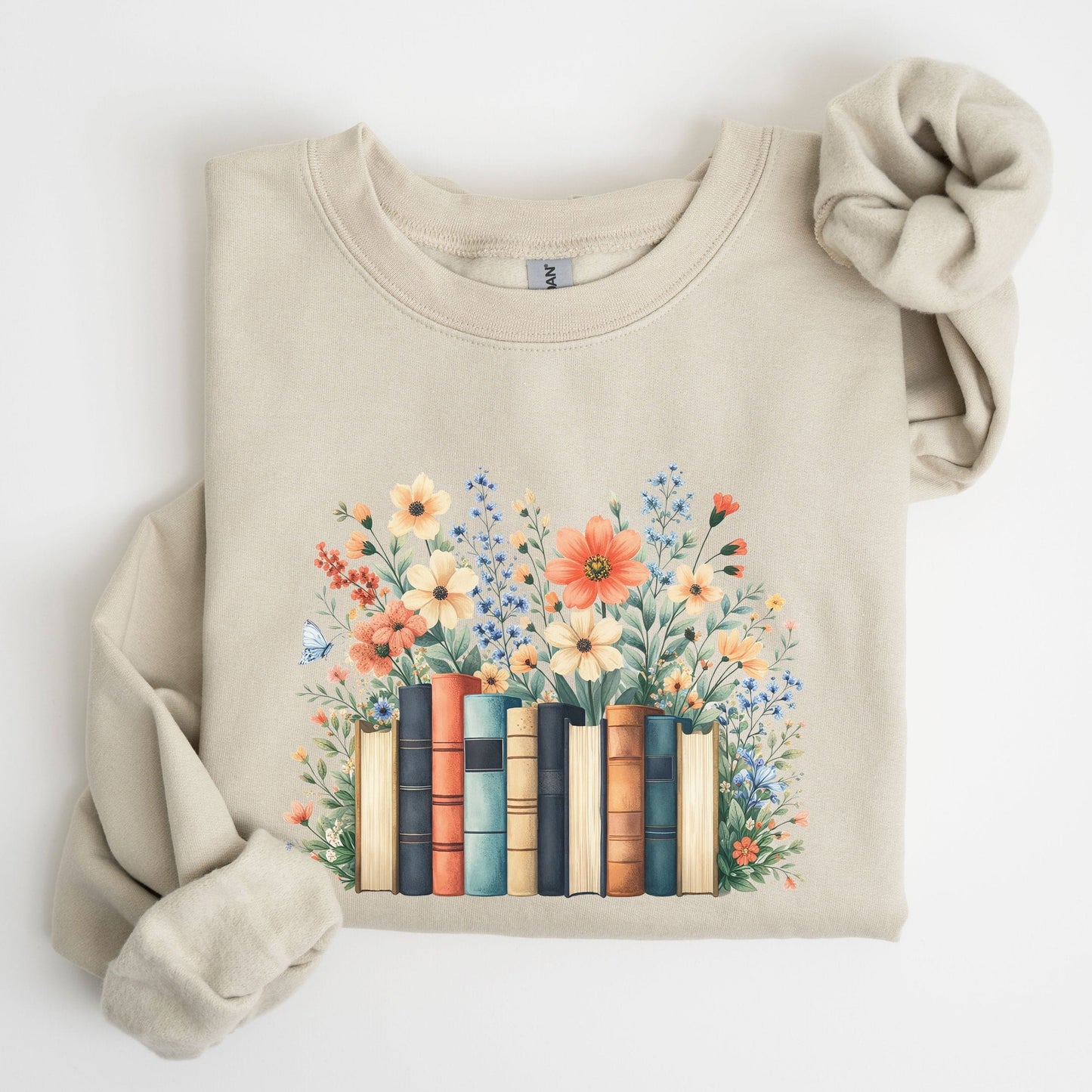 Beige sweatshirt with a design of books and flowers on a white background