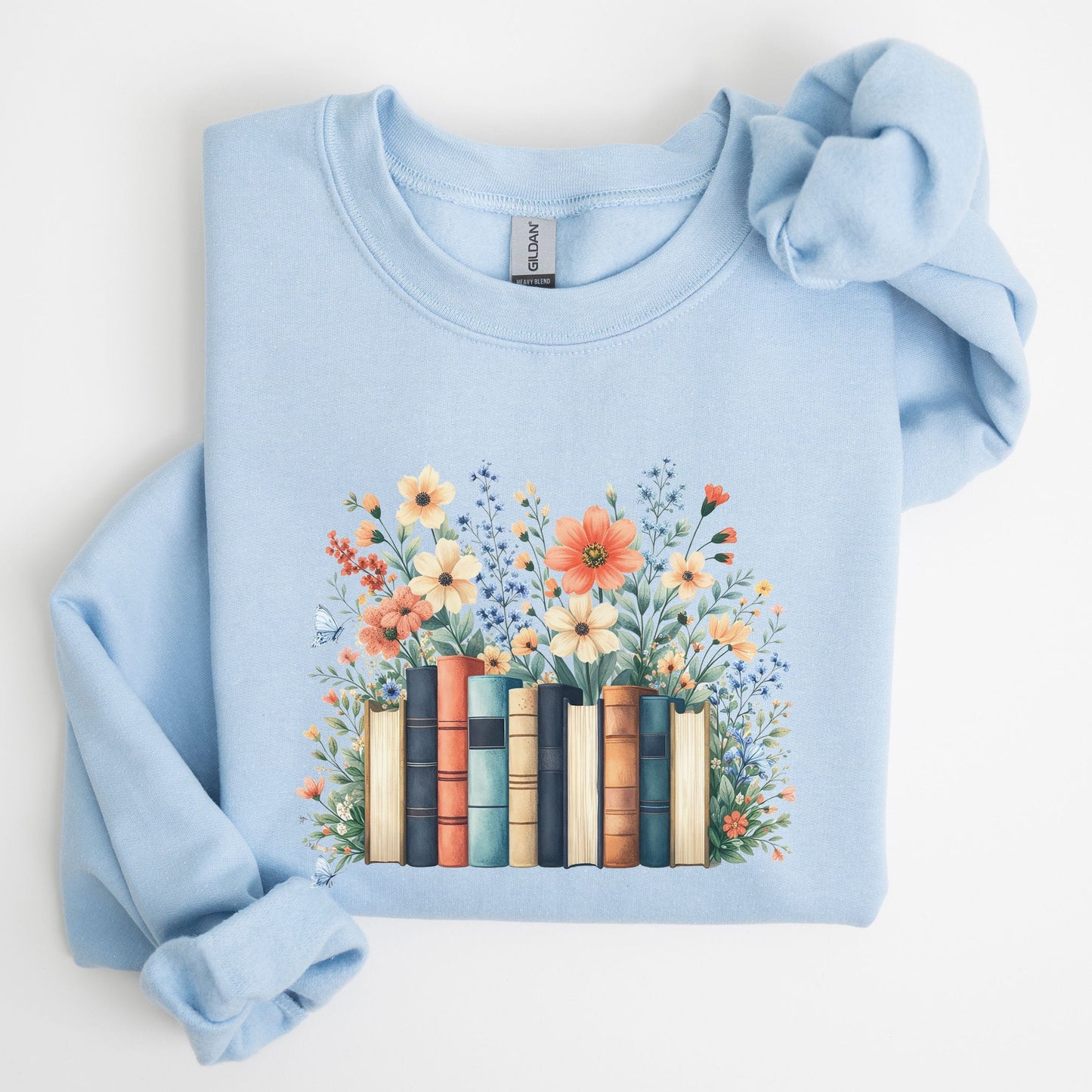 Light blue sweatshirt with floral and book design on a white background