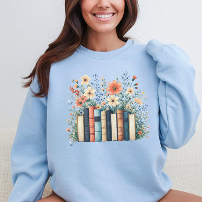 Person wearing a light blue sweatshirt with a floral and book design.