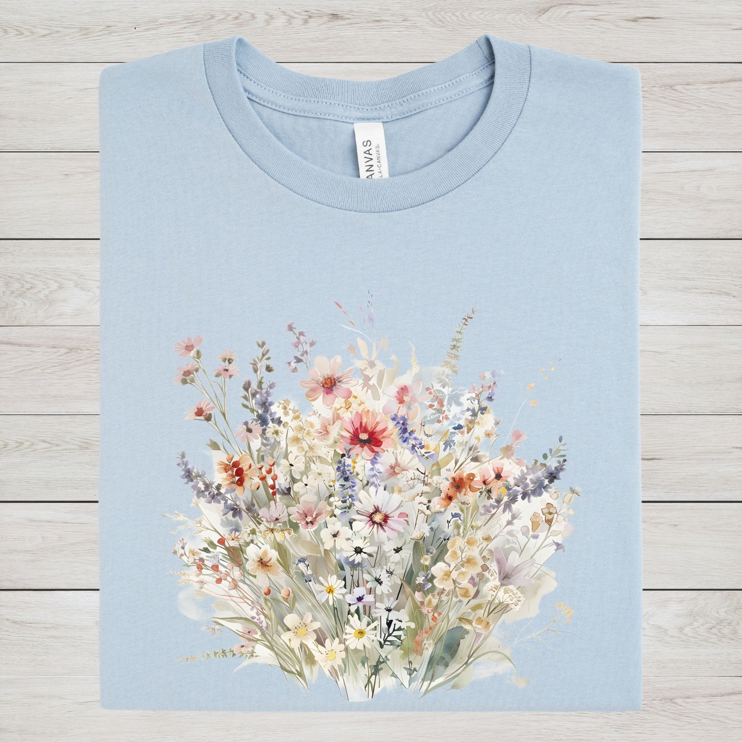 Light blue t-shirt with a floral design on a wooden surface
