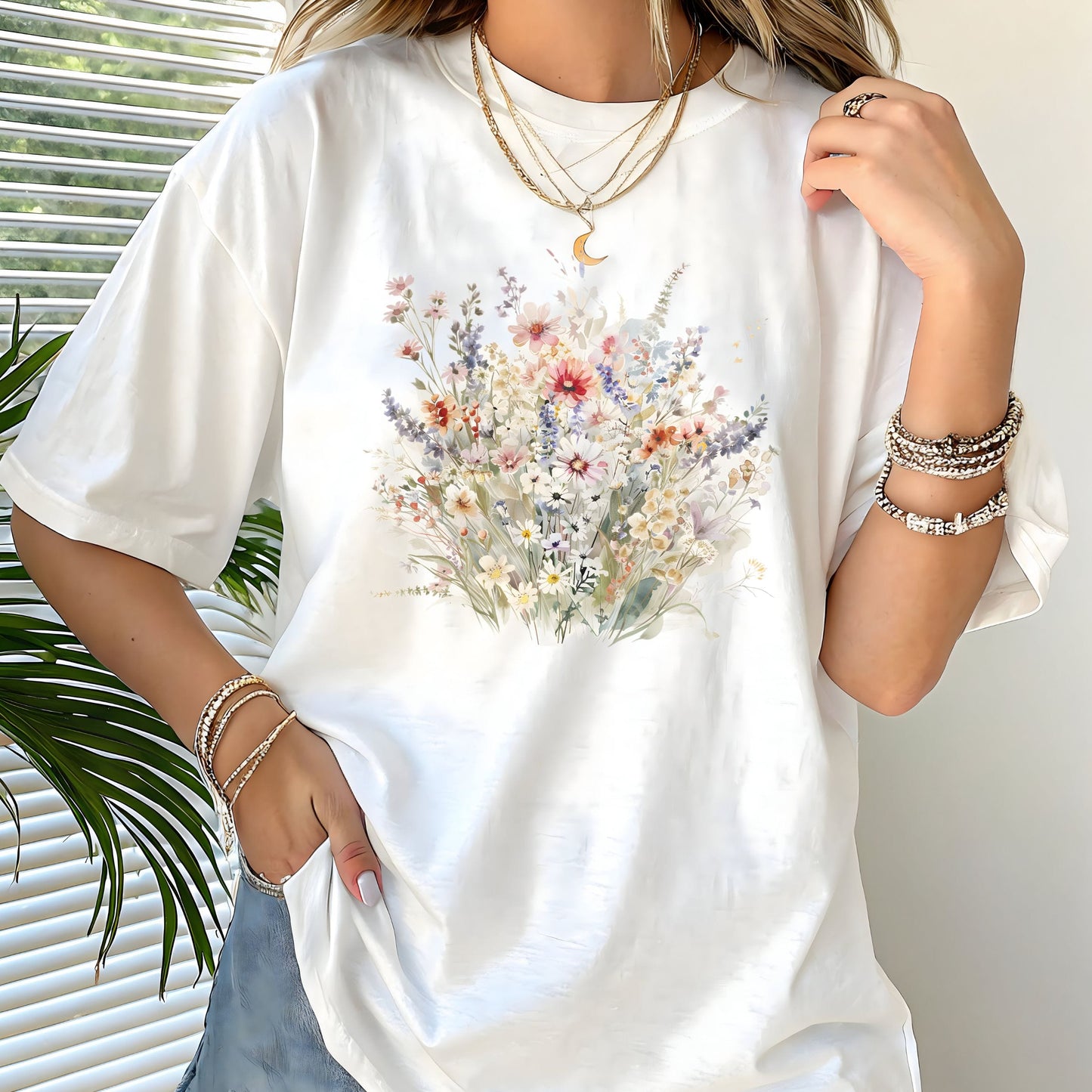 White t-shirt with floral design worn by a person, with a neutral background