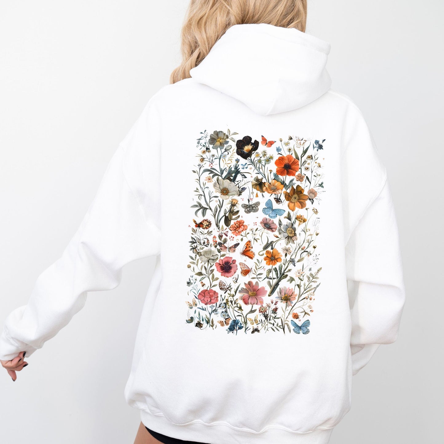 White hoodie with a colorful floral pattern on the back against a white background