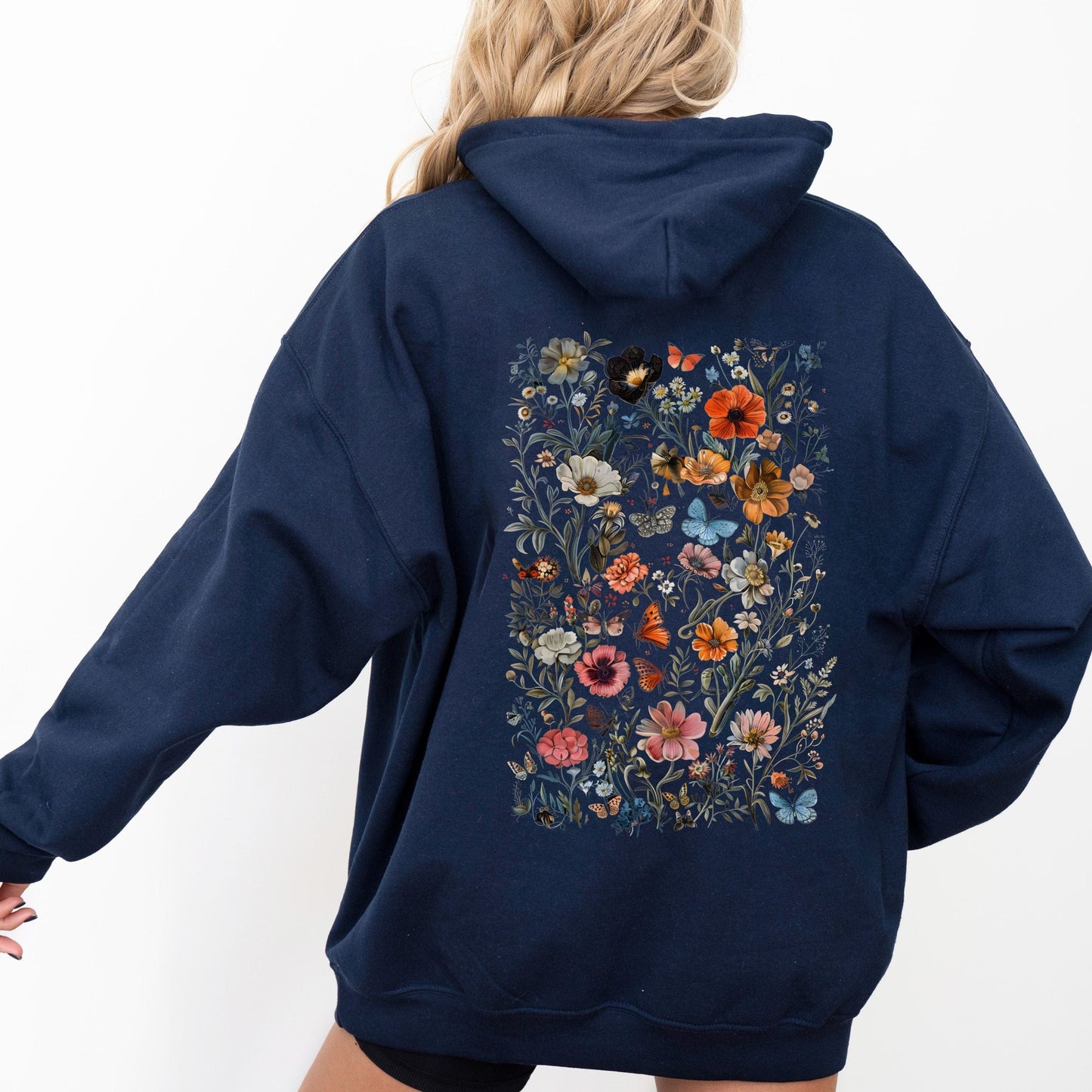 Navy blue hoodie with floral design on the back worn by a person