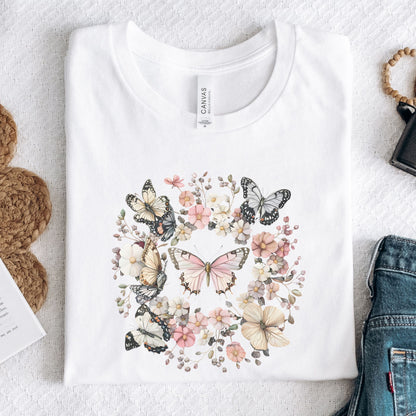 White t-shirt with butterfly and floral design on a textured surface