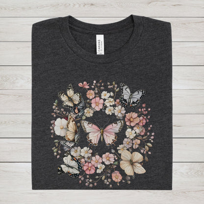 Dark gray t-shirt with butterfly and floral design on a wooden surface