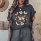 Person wearing a dark gray heather t-shirt with butterfly and floral designs, standing against a neutral background.