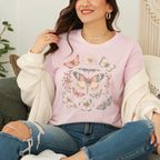 Woman wearing a soft pink t-shirt with butterfly designs, sitting on a couch.