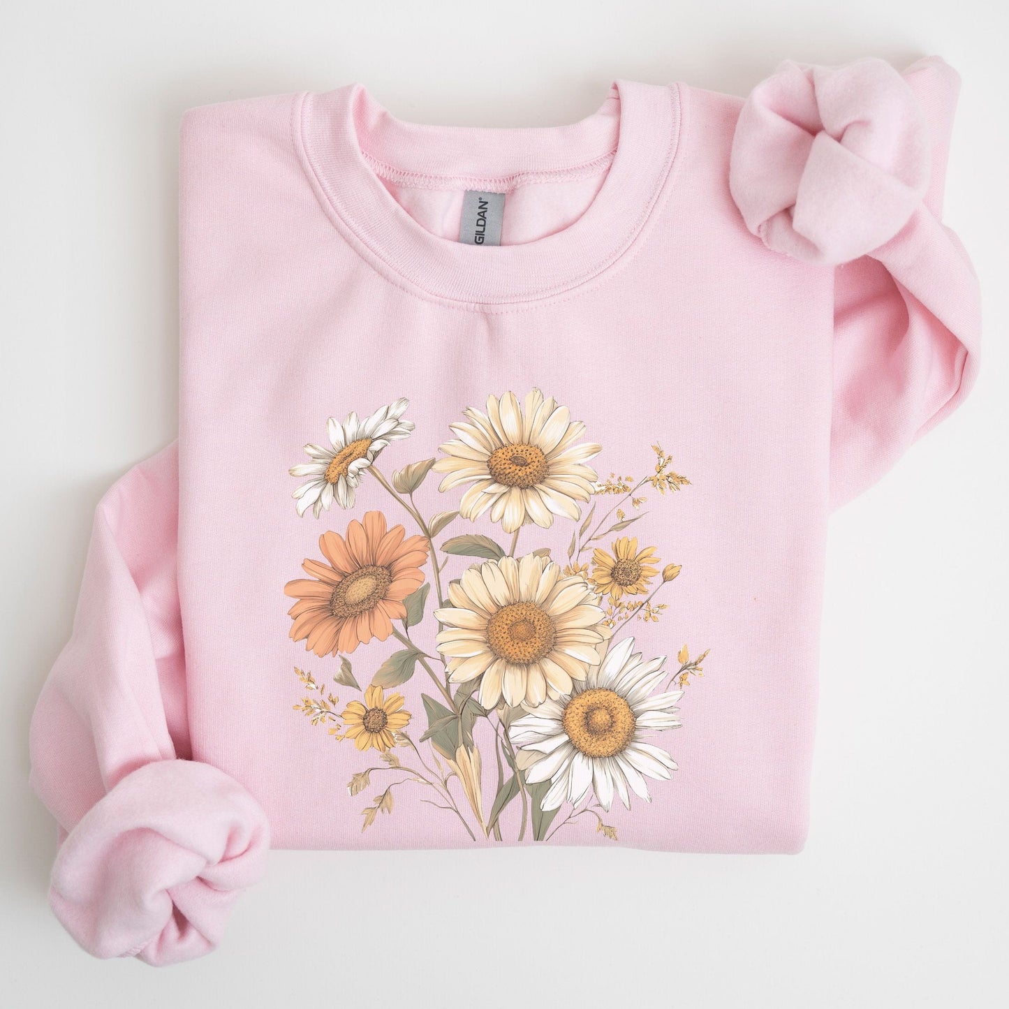 Pink sweatshirt with floral design on a light gray background