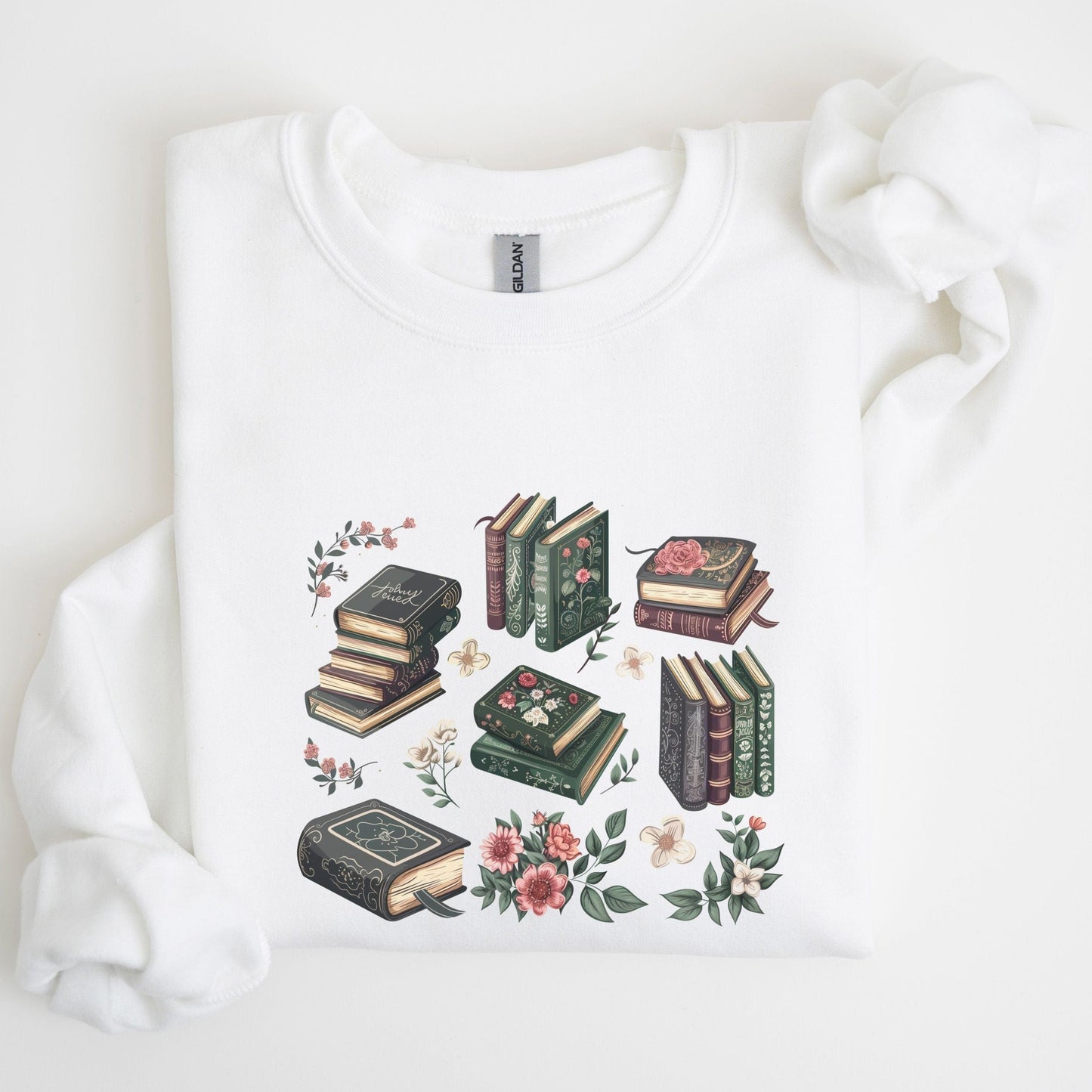 White sweatshirt with book and floral design on a light background