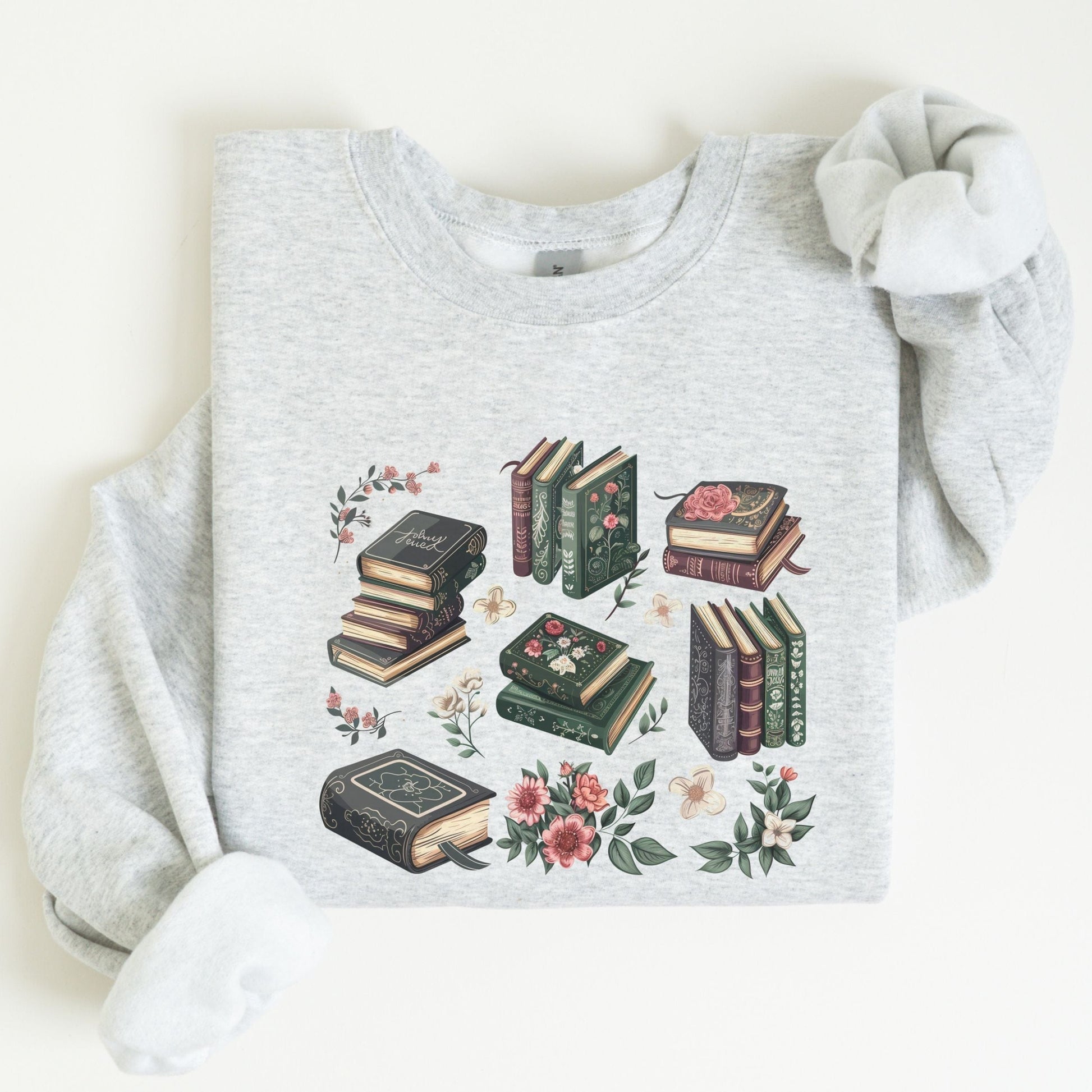 Gray sweatshirt with book and floral design on a light background