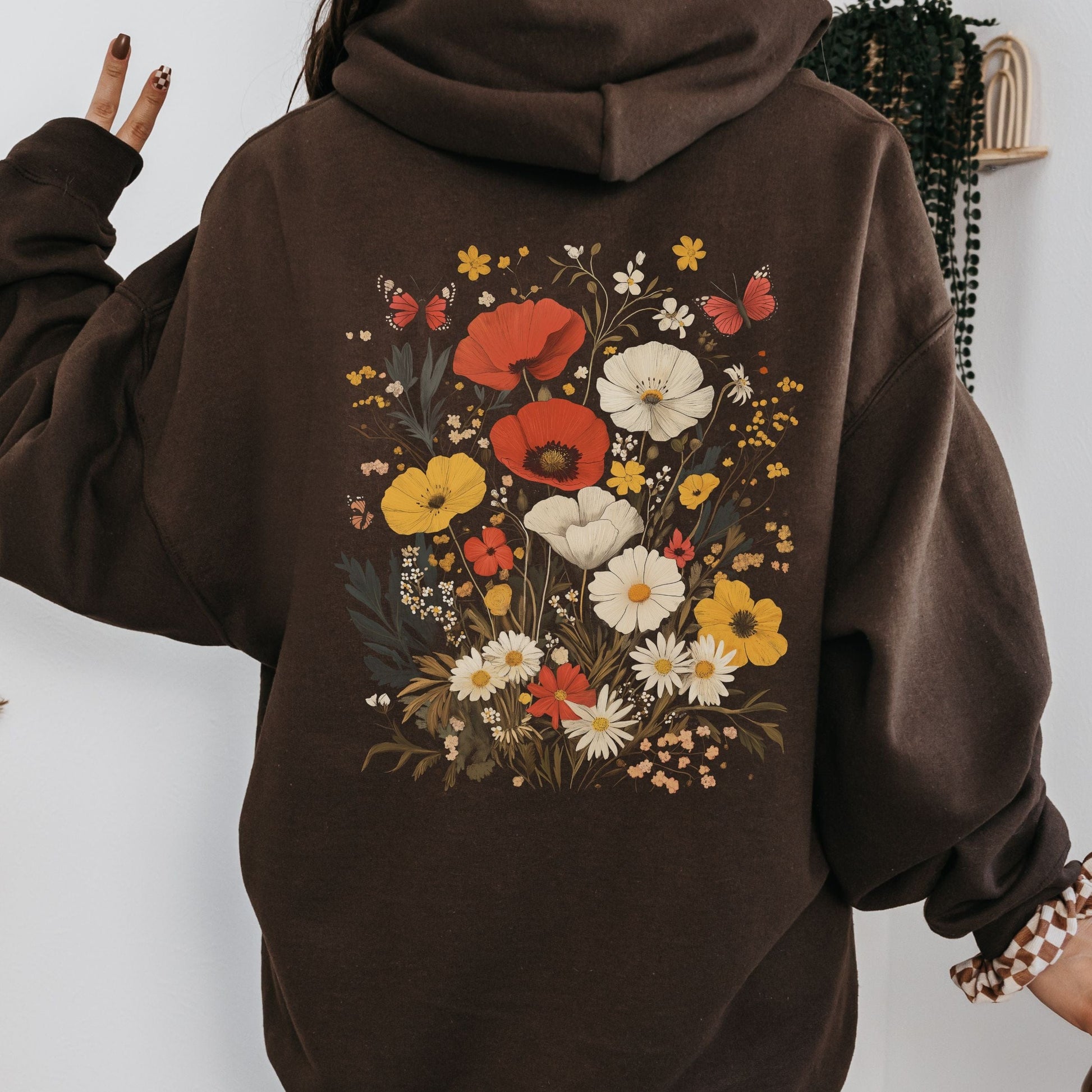 Brown hoodie with floral design on the back against a white background