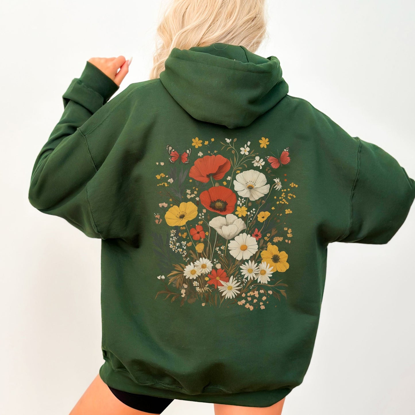 Green hoodie with floral design on the back worn by a person against a white background