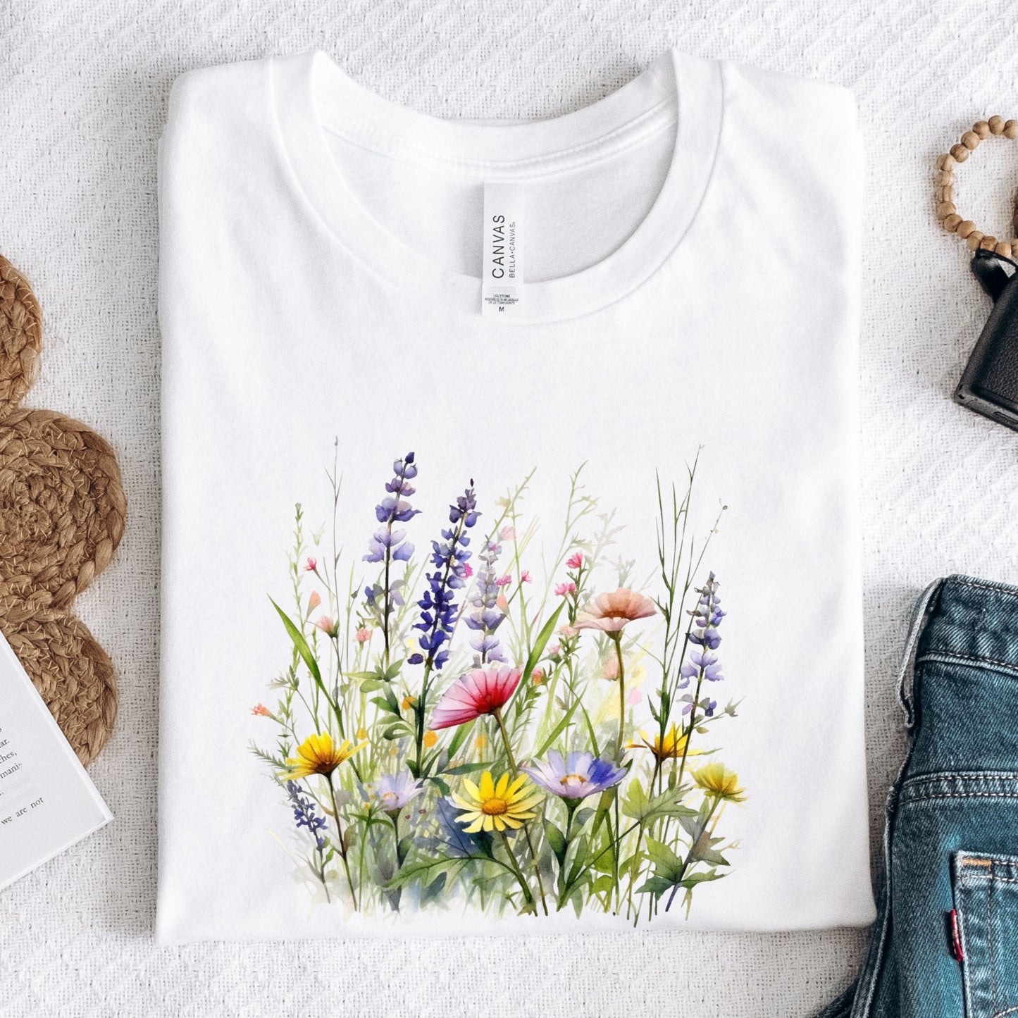 White long sleeve t-shirt with a colorful floral design on a textured surface.