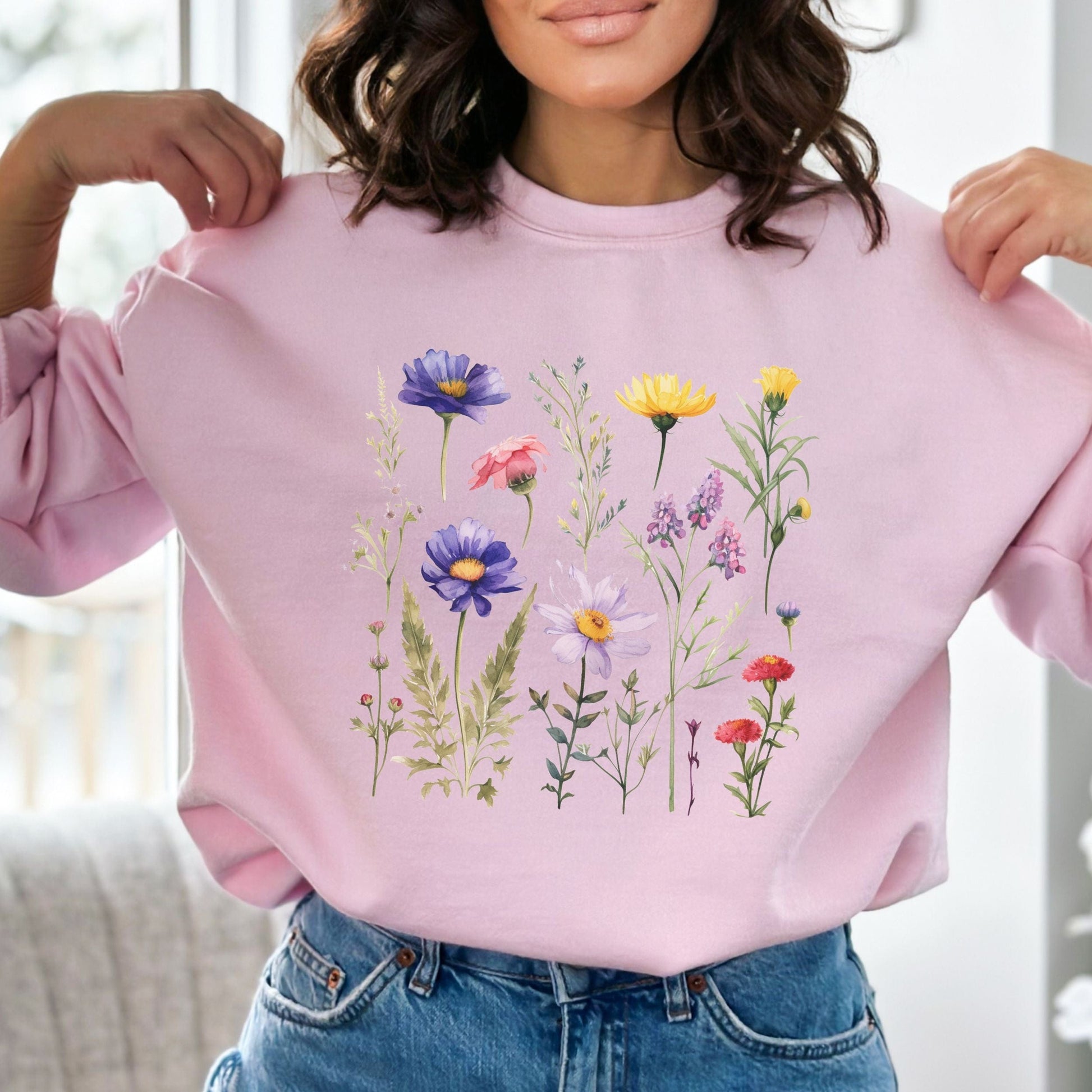 Person wearing a light pink sweatshirt with floral designs
