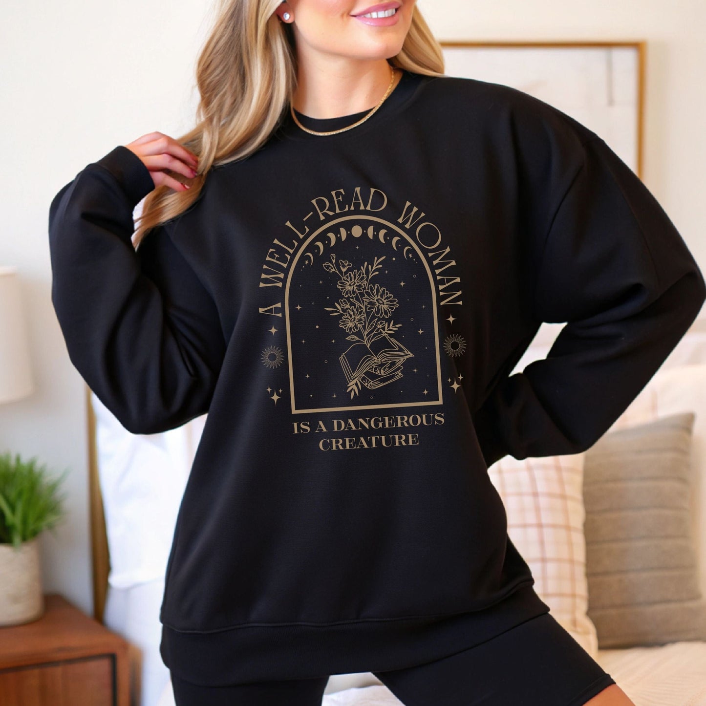 Person wearing a black sweatshirt with 'A well-read woman is a dangerous creature' text and graphic.
