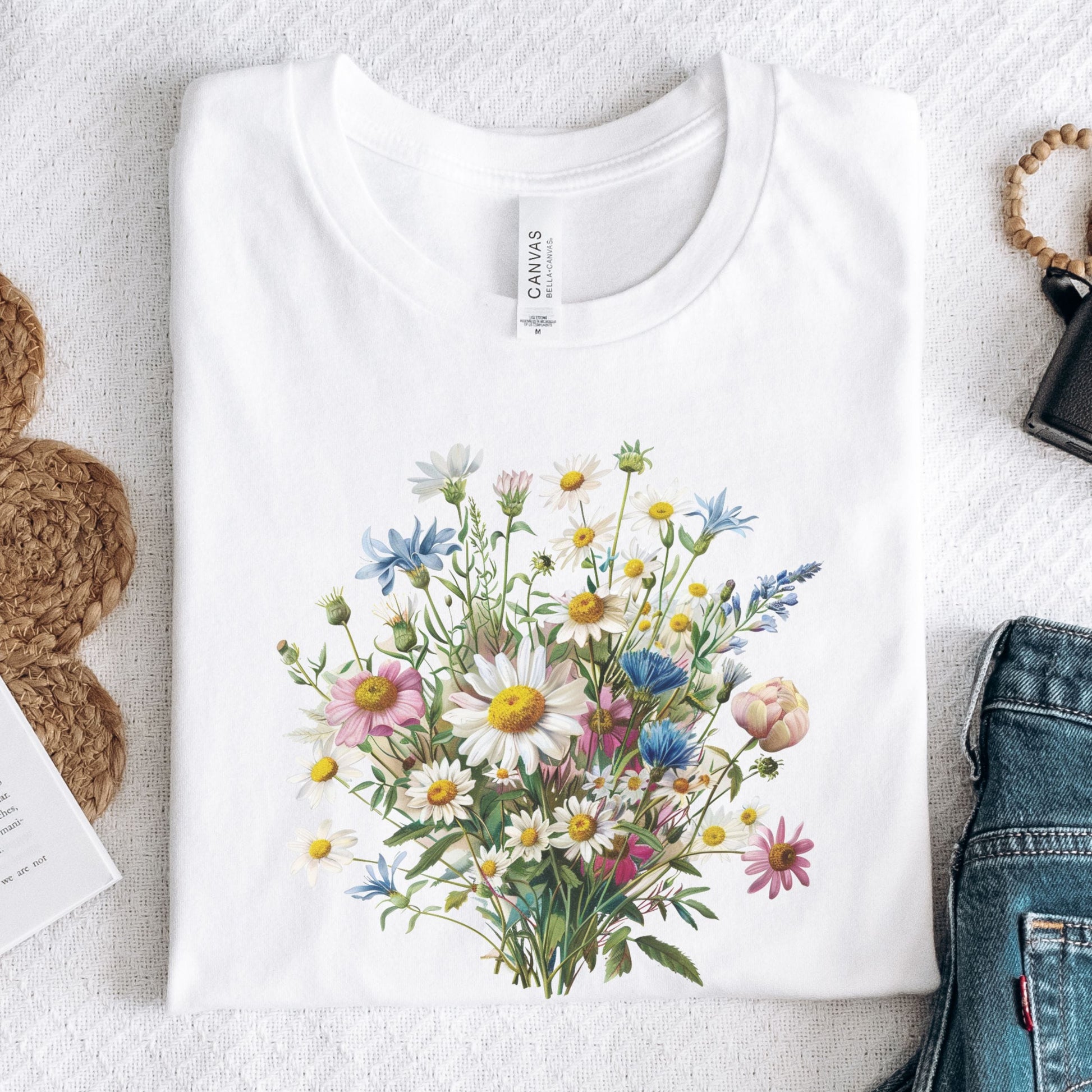 White long sleeve t-shirt with a colorful floral design on a light gray surface.