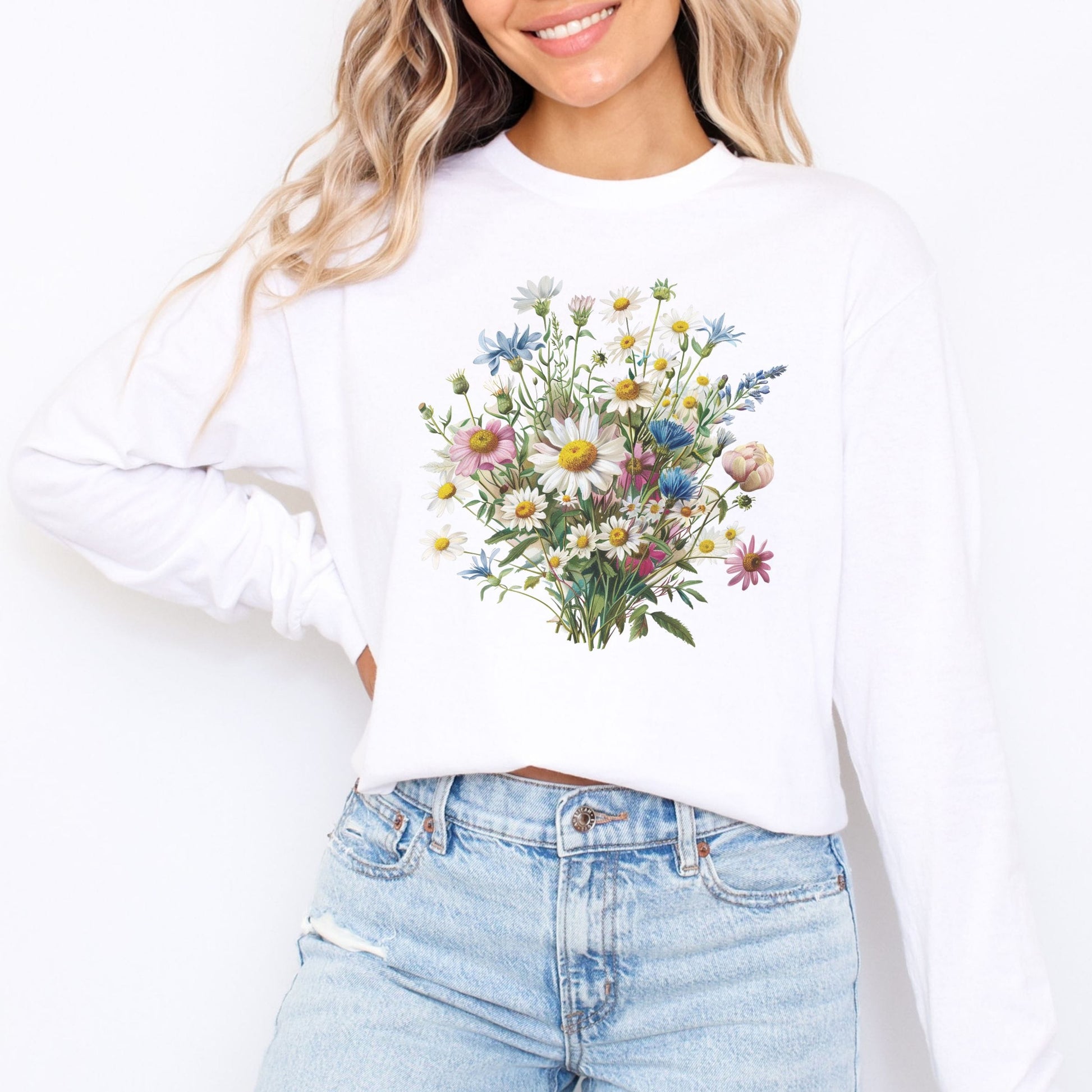 Person wearing a white long sleeve t-shirt with a floral design on a plain background