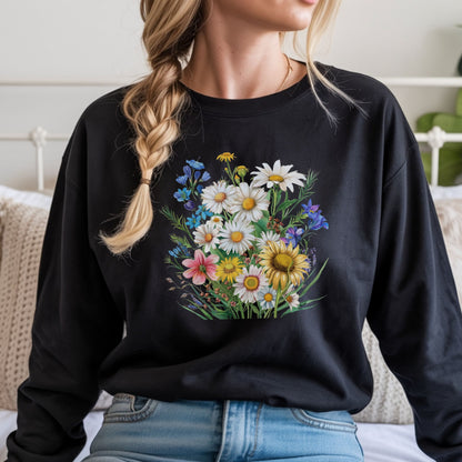 Person wearing a black long sleeve t-shirt with a floral design, sitting on a bed.