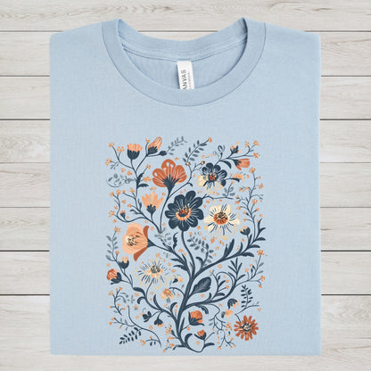 Light blue t-shirt with floral design on a wooden surface