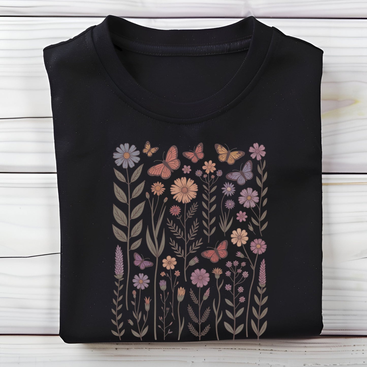 Black long sleeve t-shirt with floral and butterfly design on a wooden surface