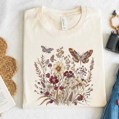 Beige t-shirt with butterfly and floral design on a textured surface