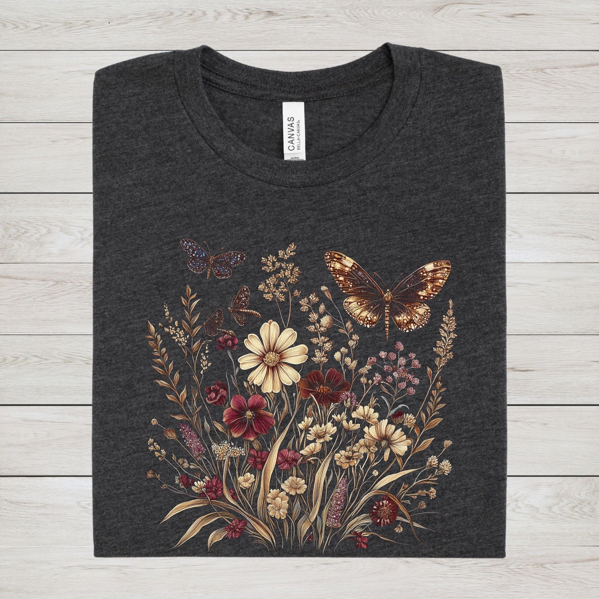 Dark grey heather t-shirt with butterfly and floral design on a textured surface