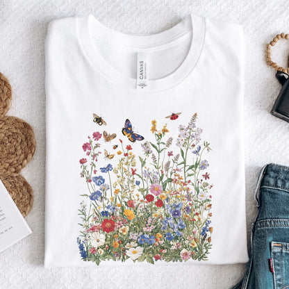 Flat lay of white t-shirt featuring colorful wildflower meadow with butterflies