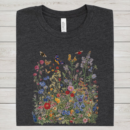 Flat lay of dark grey heather t-shirt featuring colorful wildflower meadow with butterflies