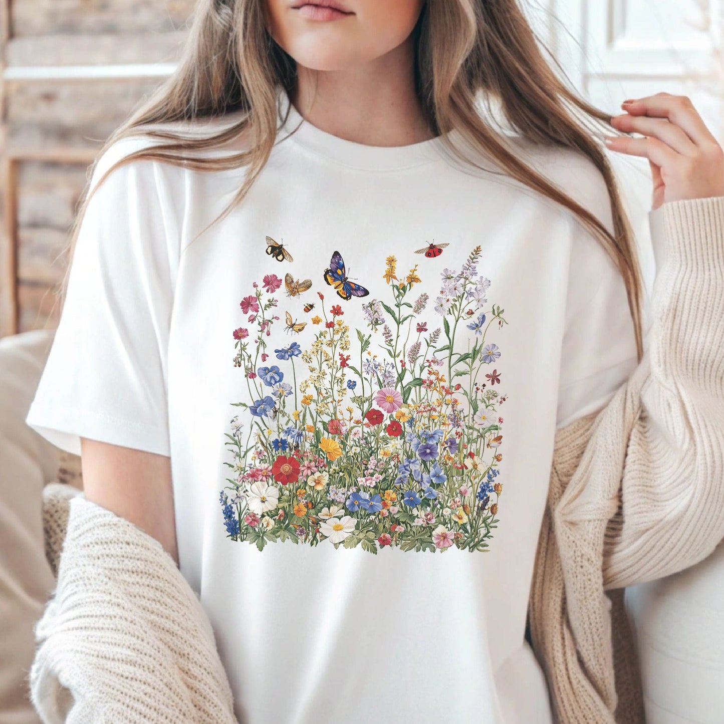 Person wearing a white t-shirt with a colorful floral and butterfly design.